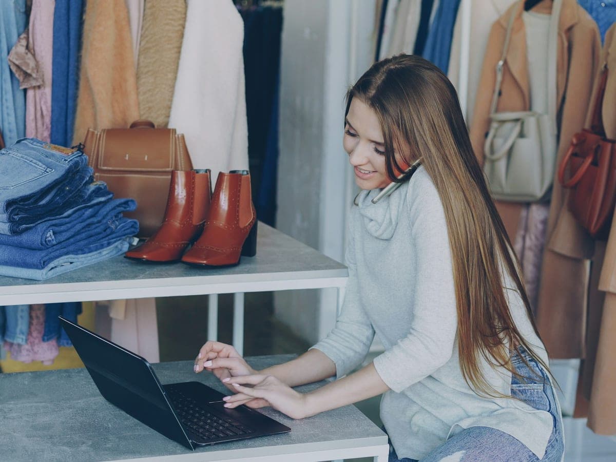 A shop owner managing her online store from a laptop