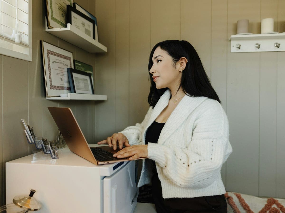 A professional working on a laptop in her practice
